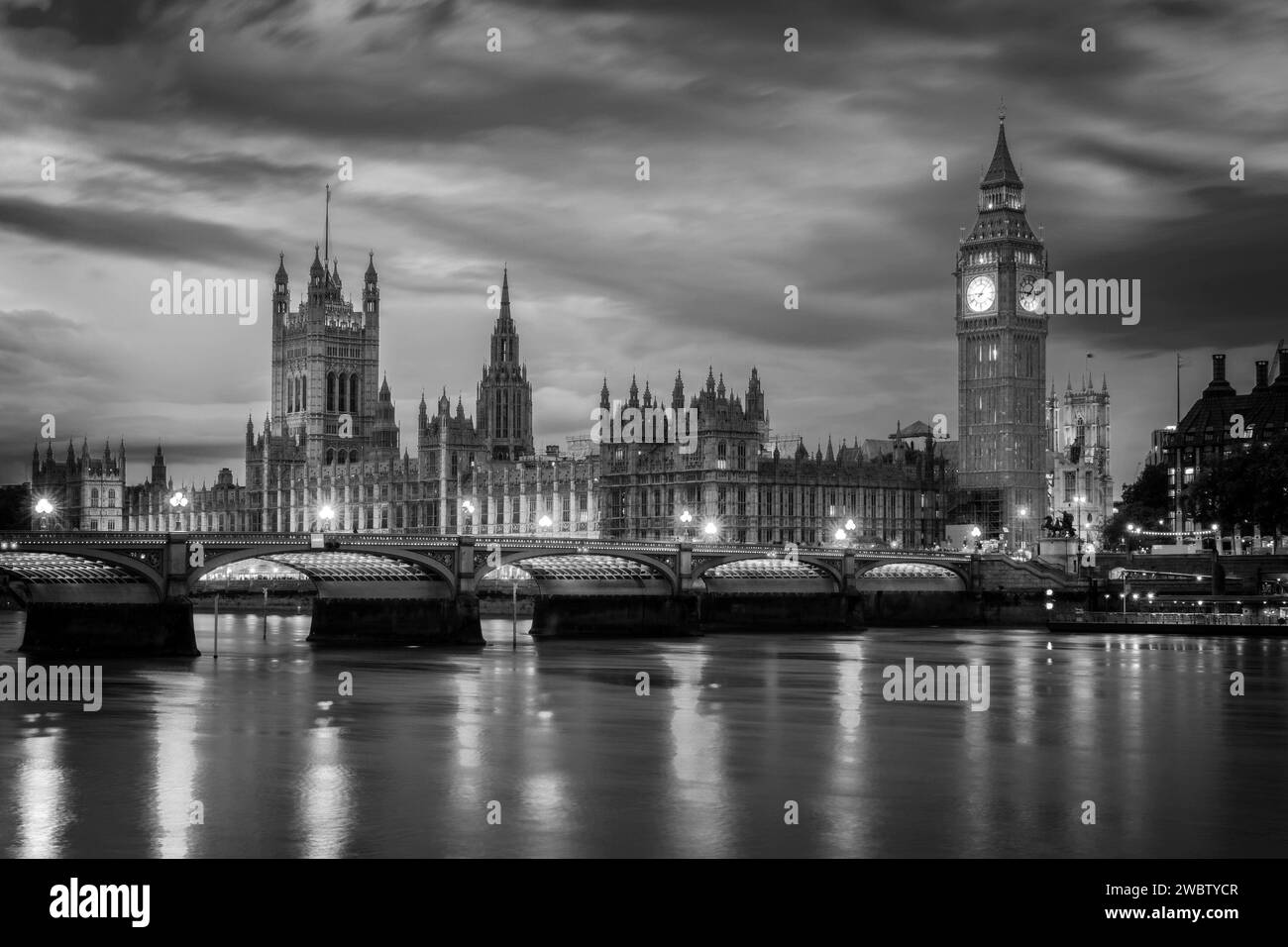 View of Westminster palace and bridge over river Thames with Big Ben illuminated at night in London, UK Stock Photo