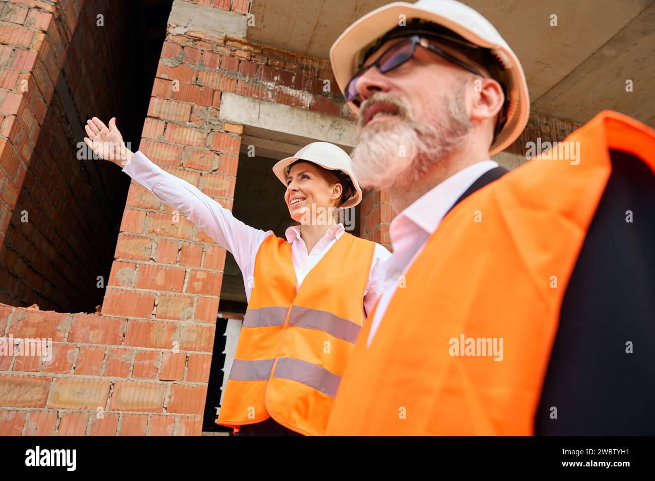 Site manager showing half-constructed building object to customer Stock Photo