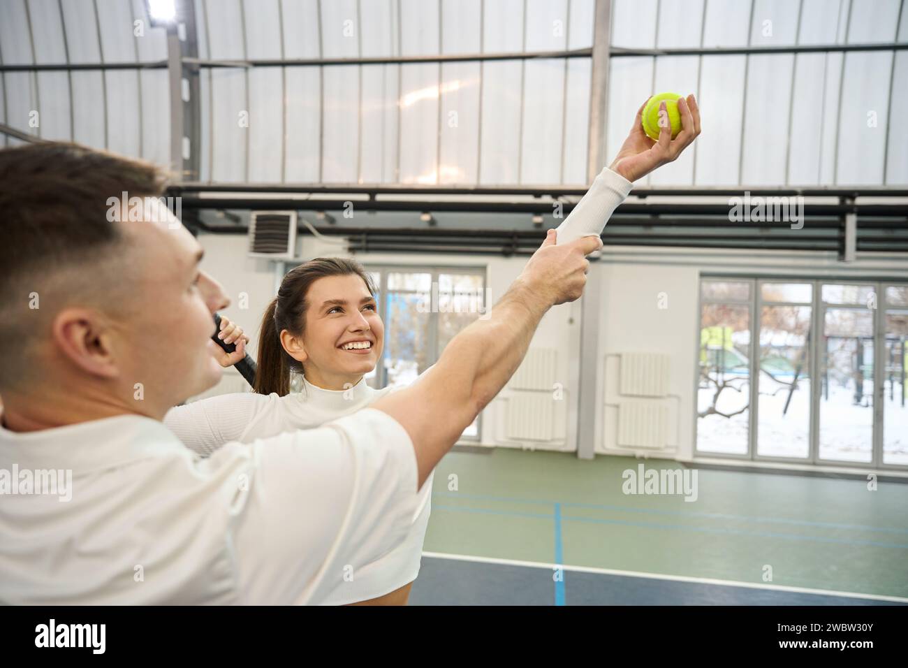 Instructor man interacting with woman beginner explaining tennis
