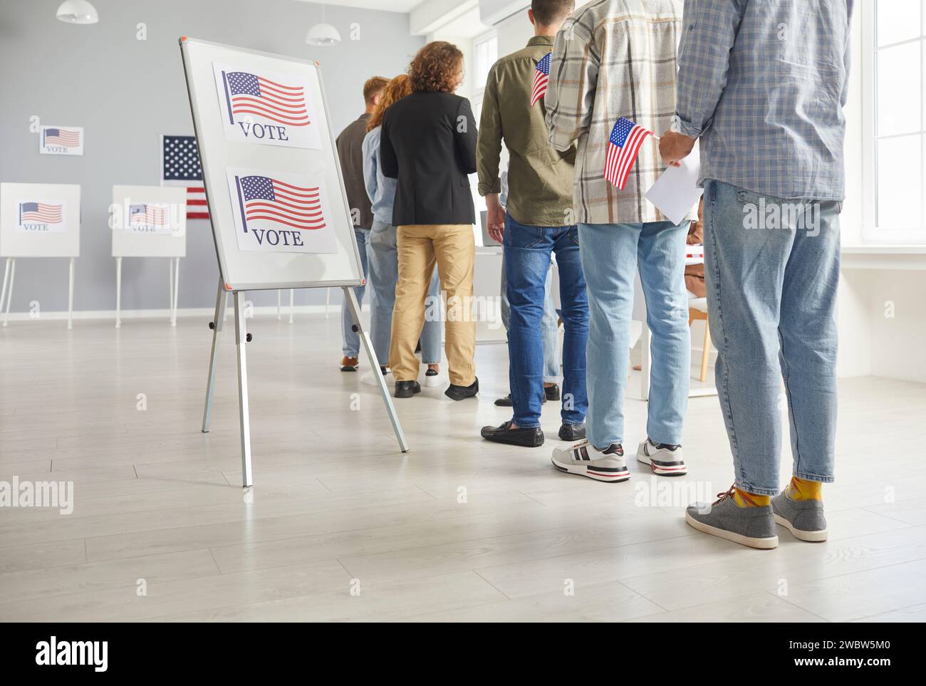 Large diverse group of people registering at polling station holding ...