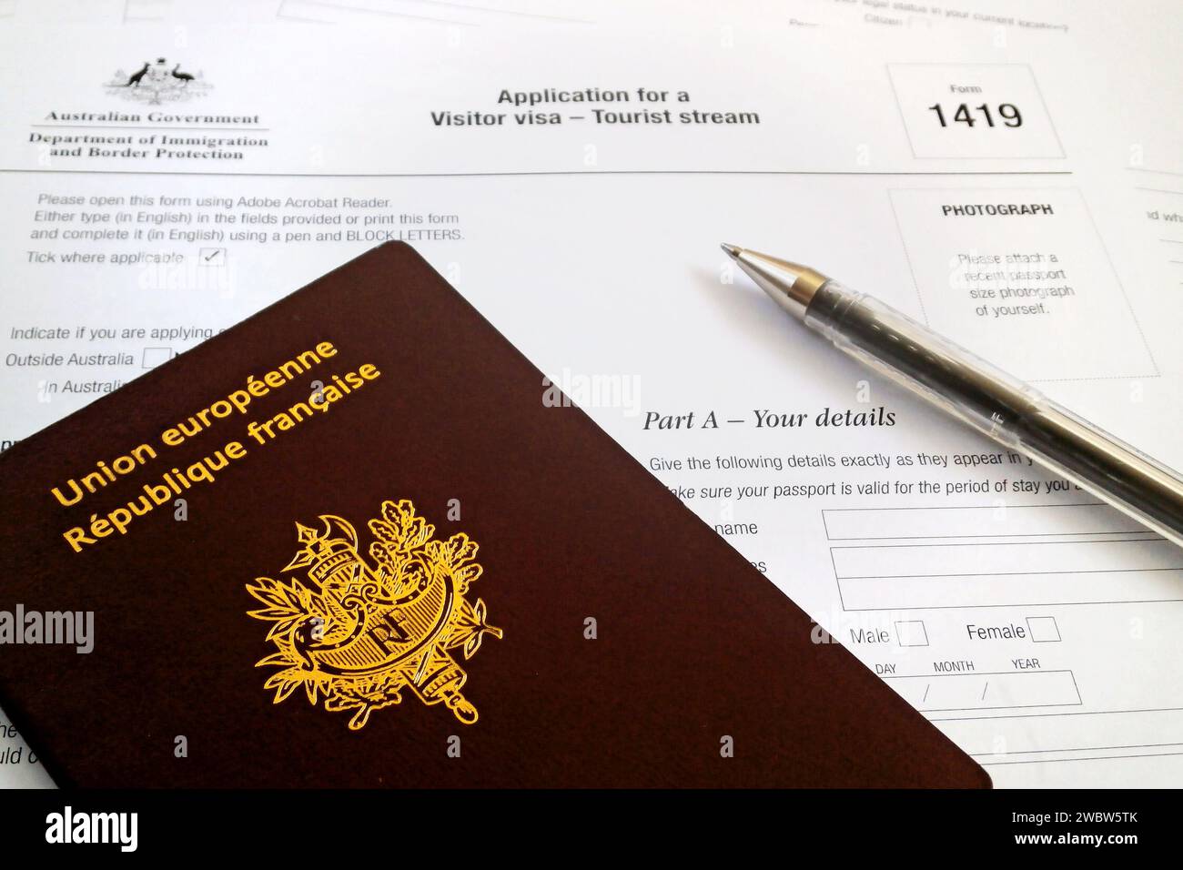 A Pen And A French Passport On The Top Of An Australian Visitor Visa Application Form Form 1419 a-pen-and-a-french-passport-on-the-top-of-an-australian-visitor-visa-application-form-form-1419