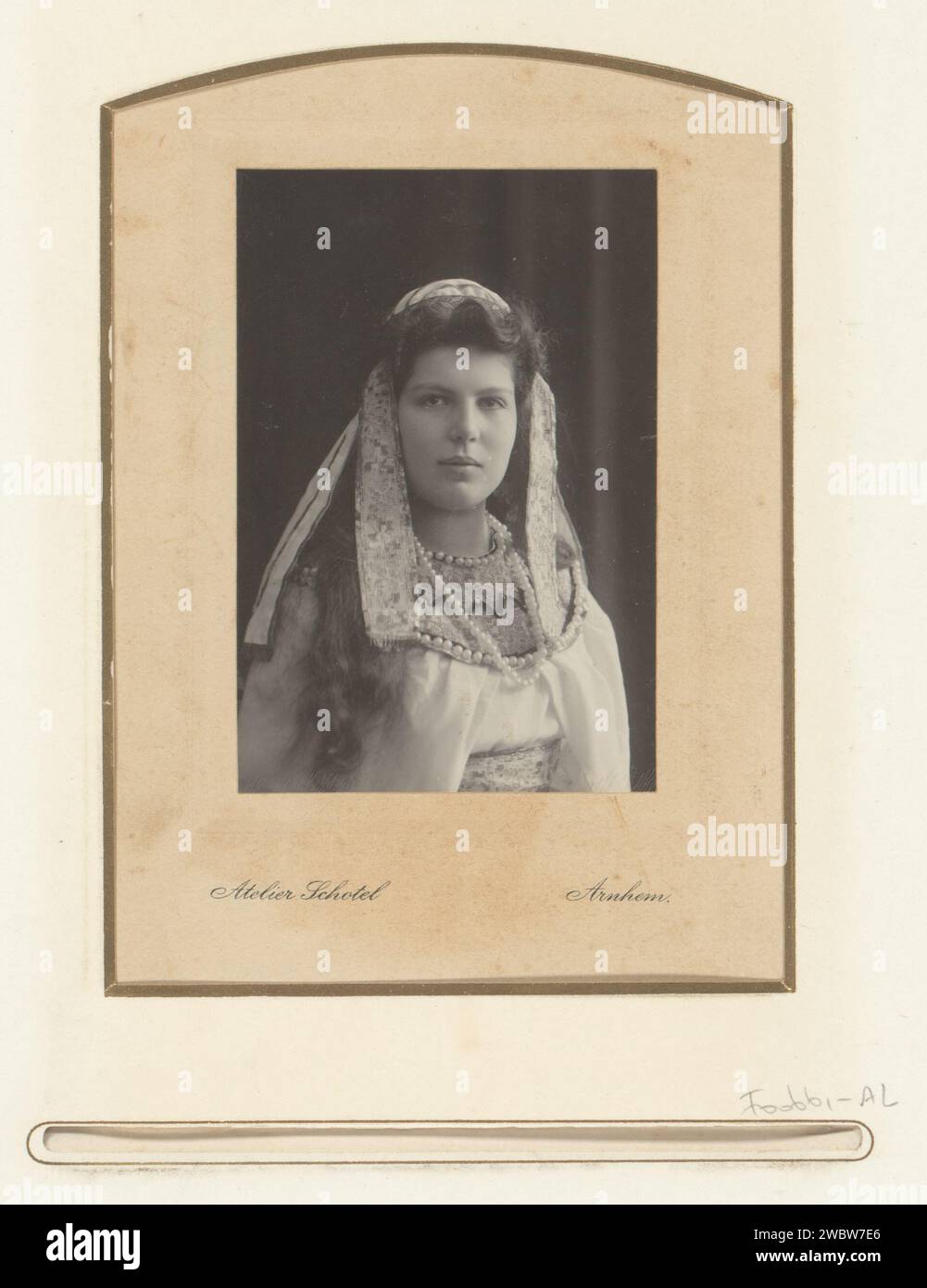 Portrait woman in Eastern costume with beads and embroidered ribbons, Stephanus Adrianus Schotel, 1902 - 1920 photograph. cabinet photograph This photo is part of an album. Arnhem cardboard. photographic support  historical persons - BB - woman. historical costume Stock Photo