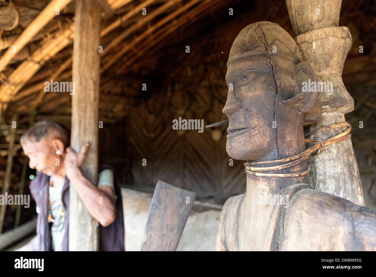 Traditional wood carved statute made by konyak tribe members at the entrance to the konyak traditional long house in longwa village, nagaland, india Stock Photo