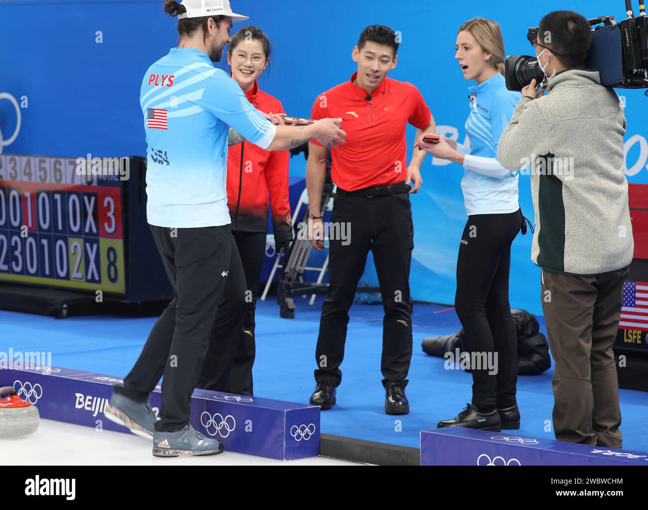 FEB 5, 2022 - Beijing, China: Fan Suyuan and Ling Zhi of Team China give gifts to their opponent Vicky Persinger and Chris Plys of Team United States Stock Photo