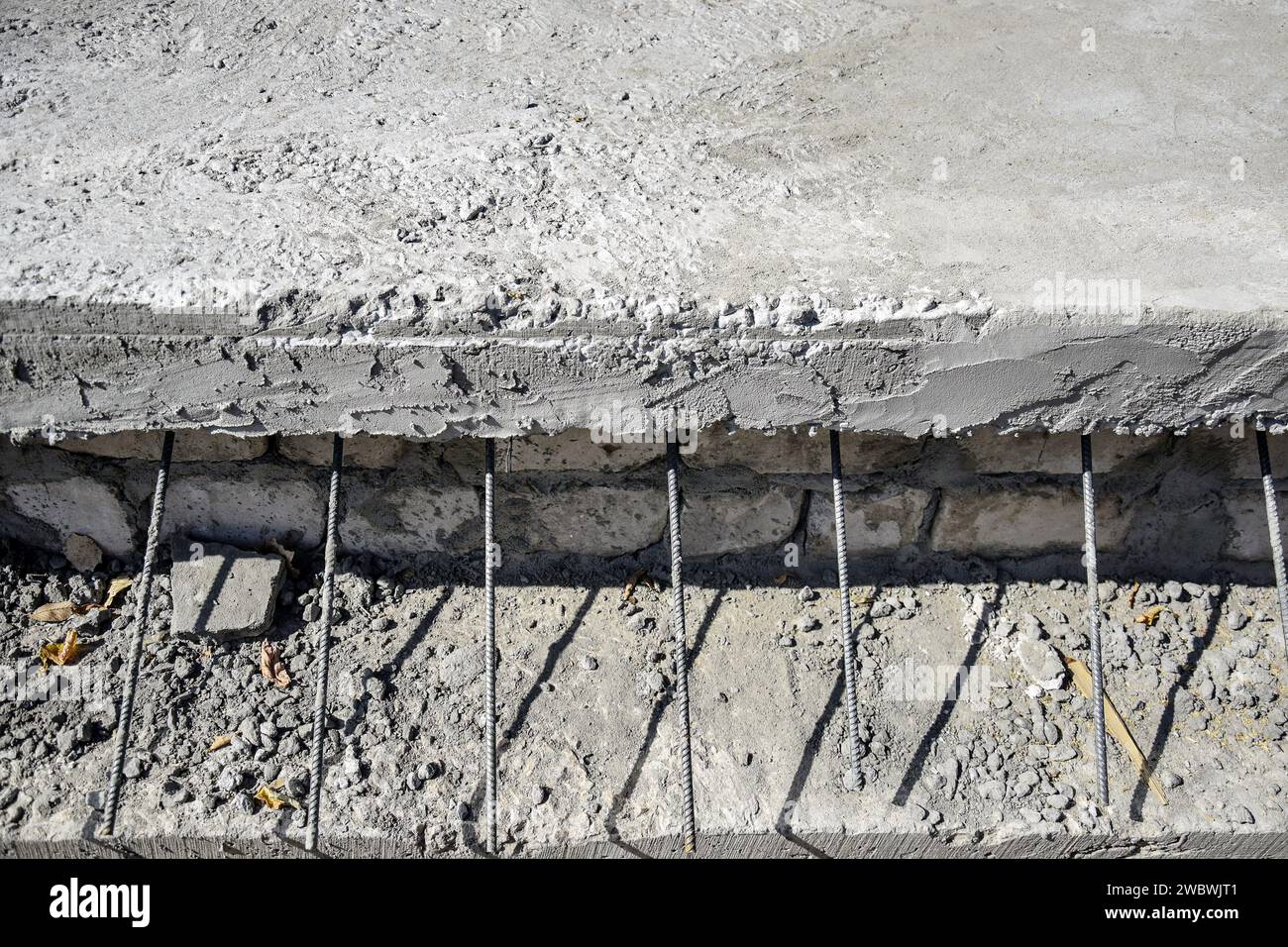 Concrete slab with protruding reinforcing metal rods. Metal fittings