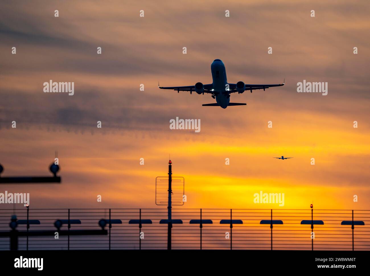 Runway lighting, approach aids, at Düsseldorf International Airport, sunset, aircraft taking off and approaching the southern main runway, 05R/23L, NR Stock Photo