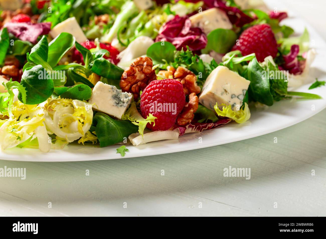 Green salad with blue cheese, raspberries and walnuts Stock Photo Alamy
