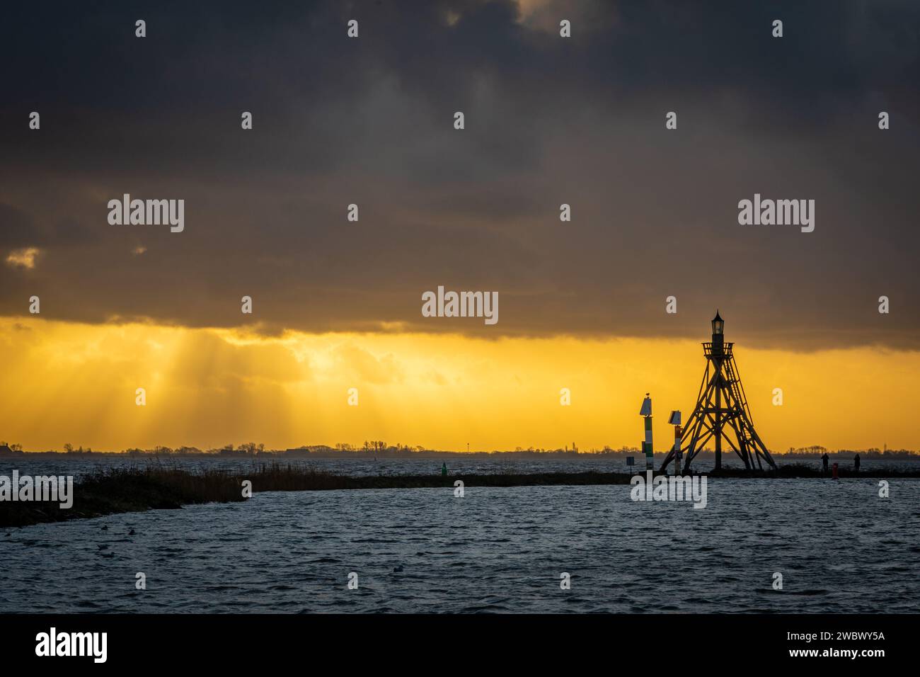 Sunset scenery with lighthouse of Hoorn in silhouette, Province North Holland, The Netherlands Stock Photo