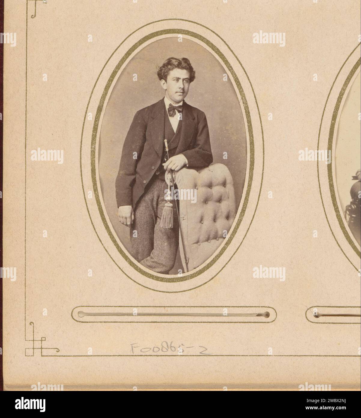 Portrait of a young man with a staff in hand, leaning on the handrail of a chair, Kannemans & Son, 1867 - 1879 Photograph. visit card This photo is part of an album. Breda cardboard. photographic support albumen print historical persons. youth, adolescent. chair. walking-stick, staff Stock Photo