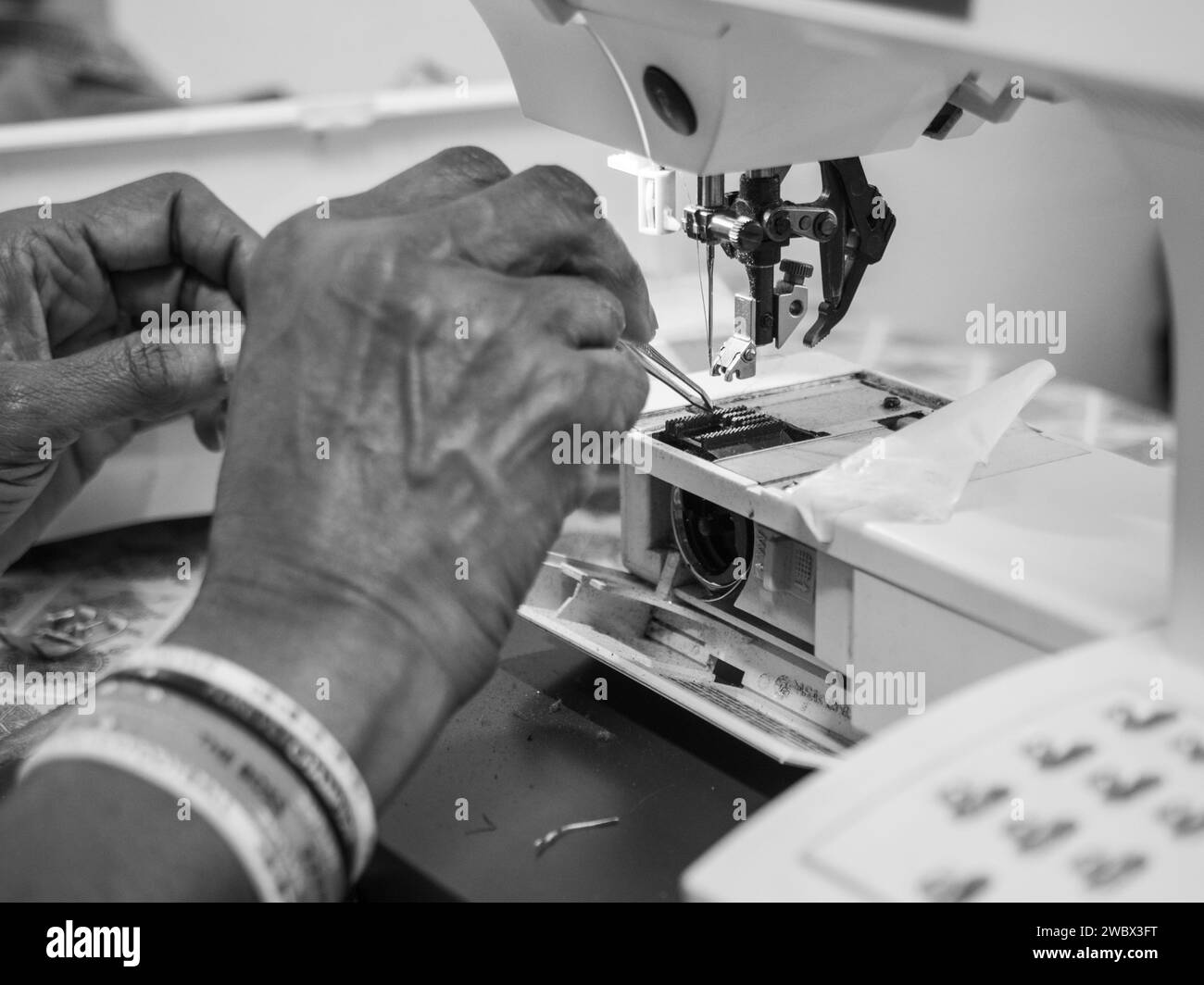 african adult black seamstress use sewing machine to skillfully sew a