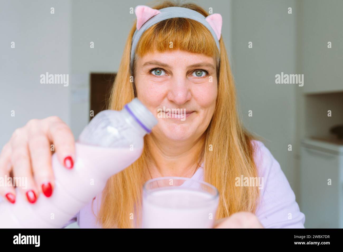 Middle aged woman drinking yogurt Stock Photo