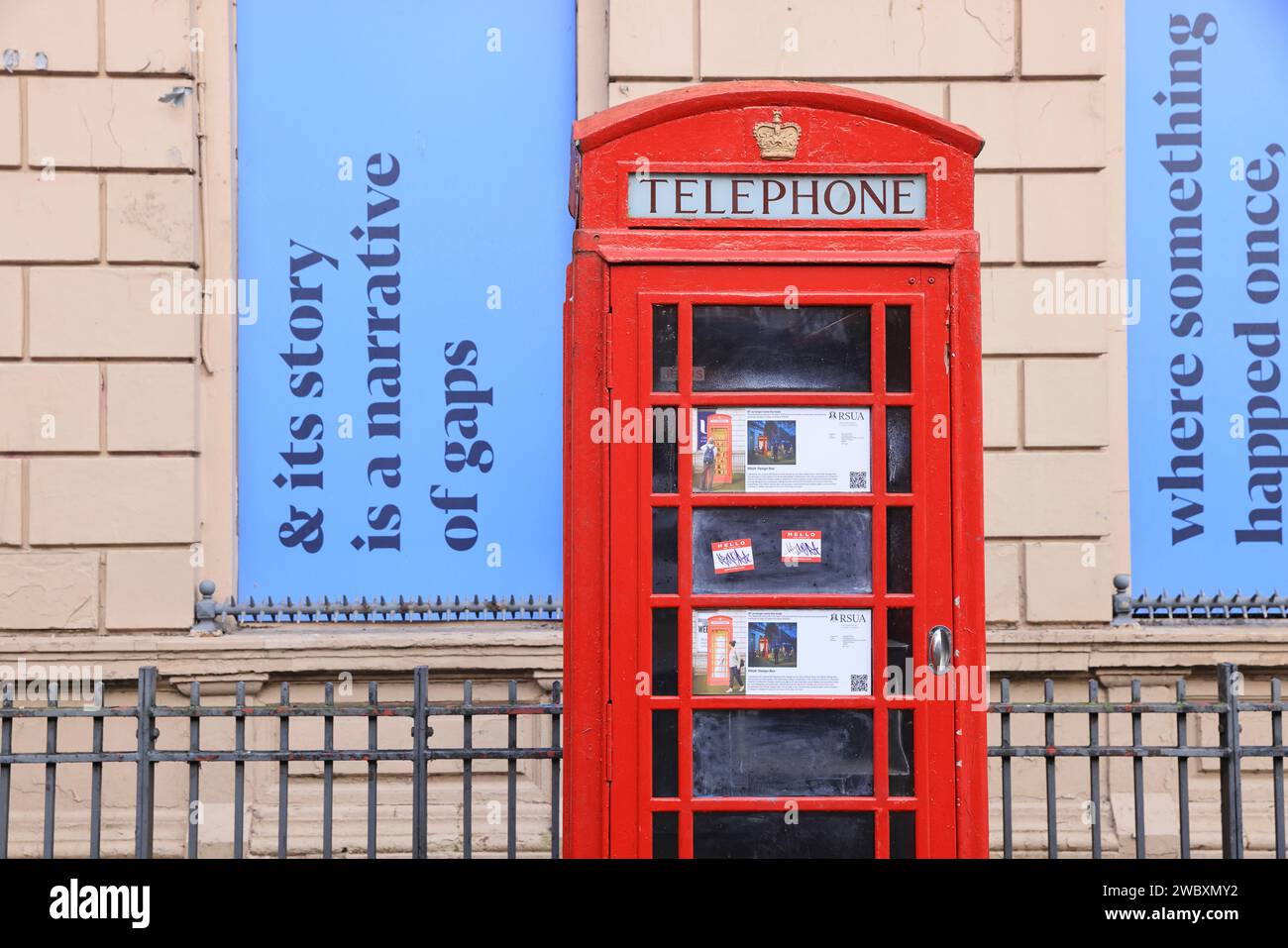 Poerty behind a red telephone box on North Street in the Cathedral Quarter, in Belfast, NI, UK Stock Photo