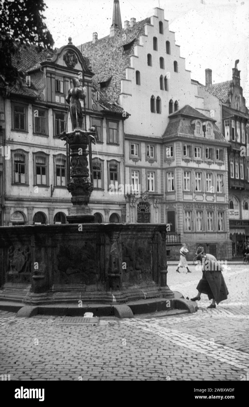 historical image of Town Square, Stadtplatz with fountain, woman, Hildesheim, 1930s, Germany, it is a Black and white image with scratches Stock Photo