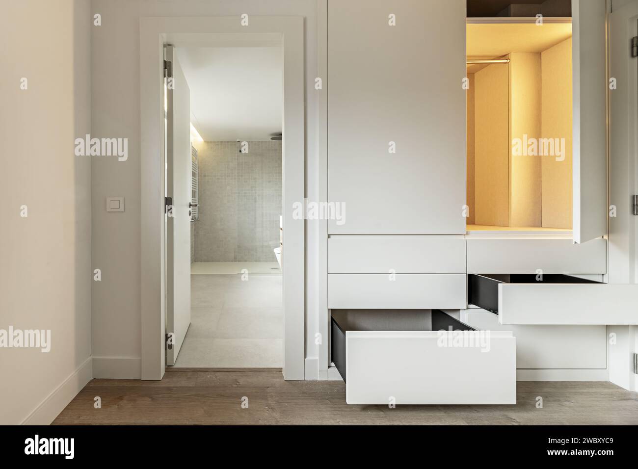 A bedroom with access door to a private bathroom and builtin wardrobe