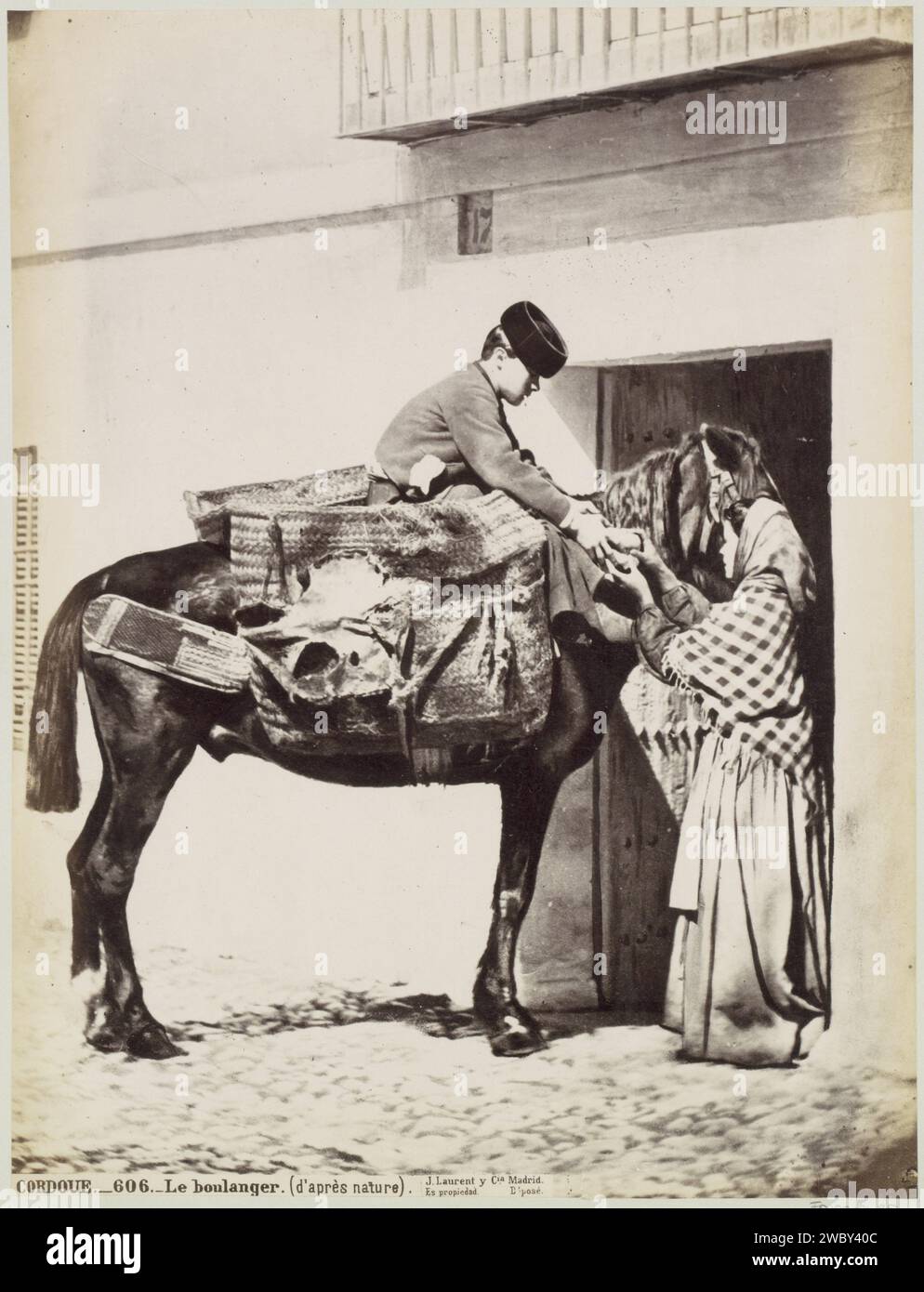 Woman buys bread from Bakker on horseback in Córdoba, Juan Laurent, c. 1857 - c. 1880 photograph Part of Reisalbum with photos of sights in Spain and Morocco. Córdoba cardboard. paper. photographic support albumen print street-trader. horse Córdoba Stock Photo