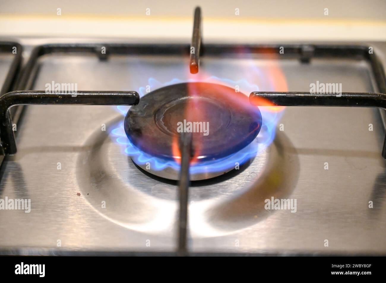 Gas cooker in kitchen. Close up of blue flames on gas stove burner in