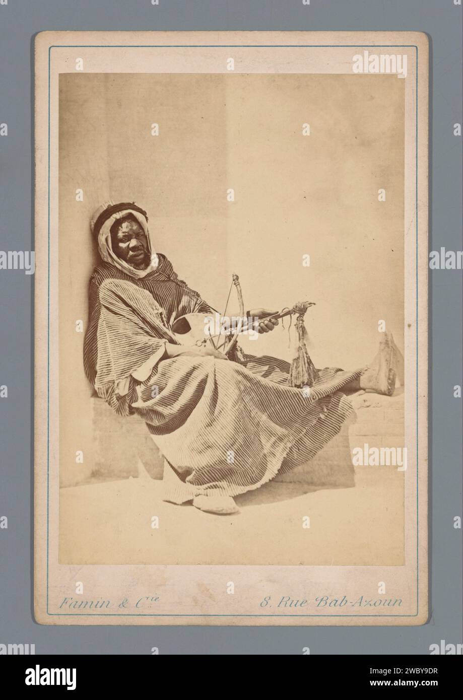 Black man with musical instrument, Famin et Cie., 1863 - 1889 cabinet photograph  Algeria cardboard. photographic support albumen print anonymous historical person portrayed. Africans. string instruments (bowed) Algeria Stock Photo