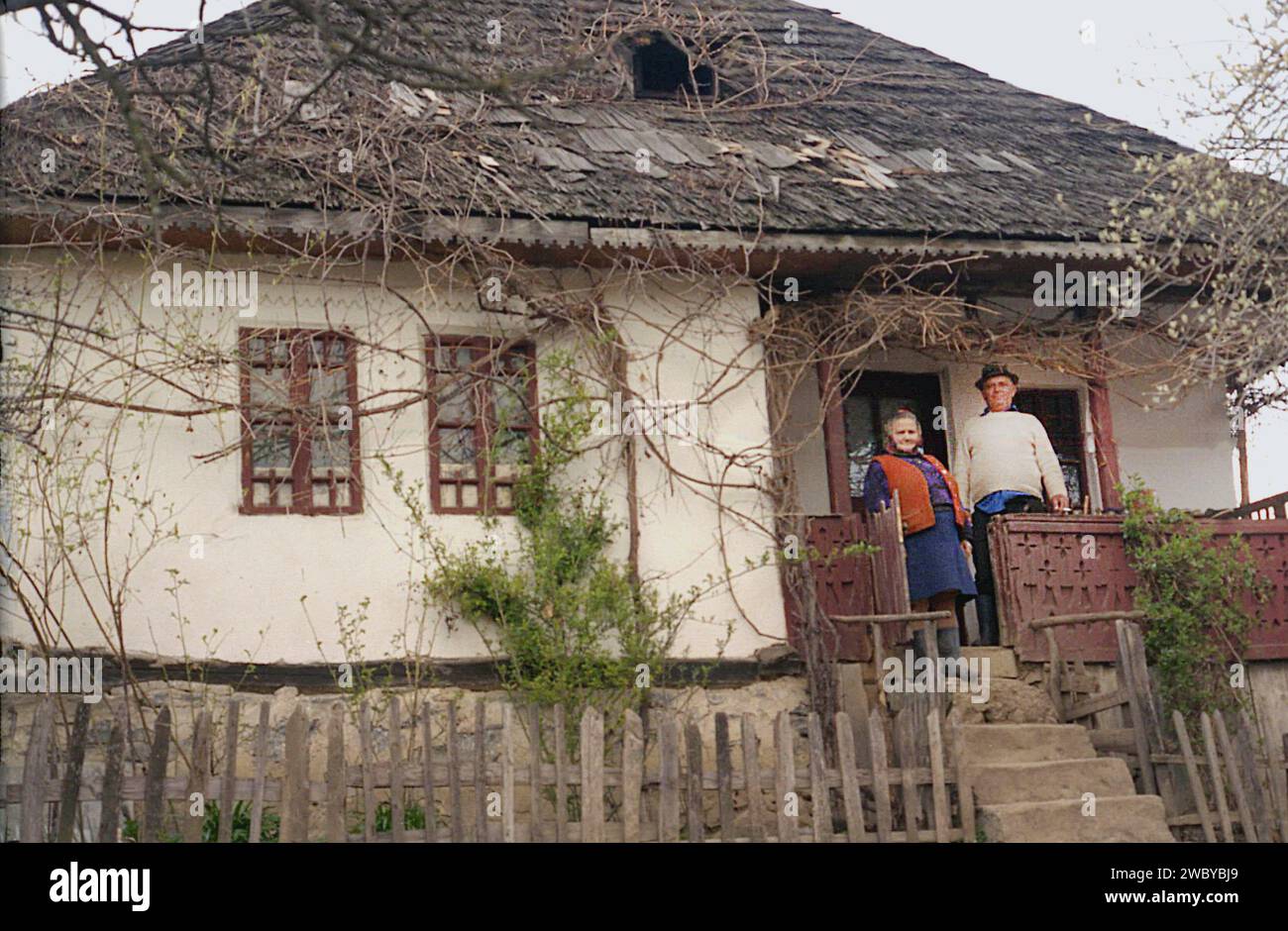 Arges County, Romania, approx. 1999. Elderly couple on the porch of their old, traditional house. Stock Photo