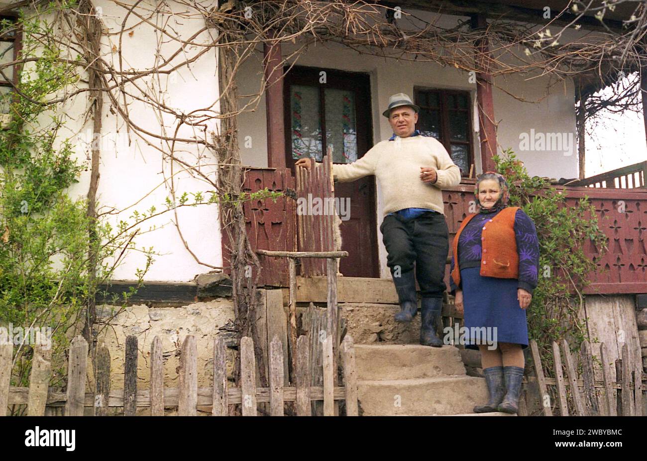 Arges County, Romania, approx. 1999. Elderly couple on the porch of their old, traditional house. Stock Photo
