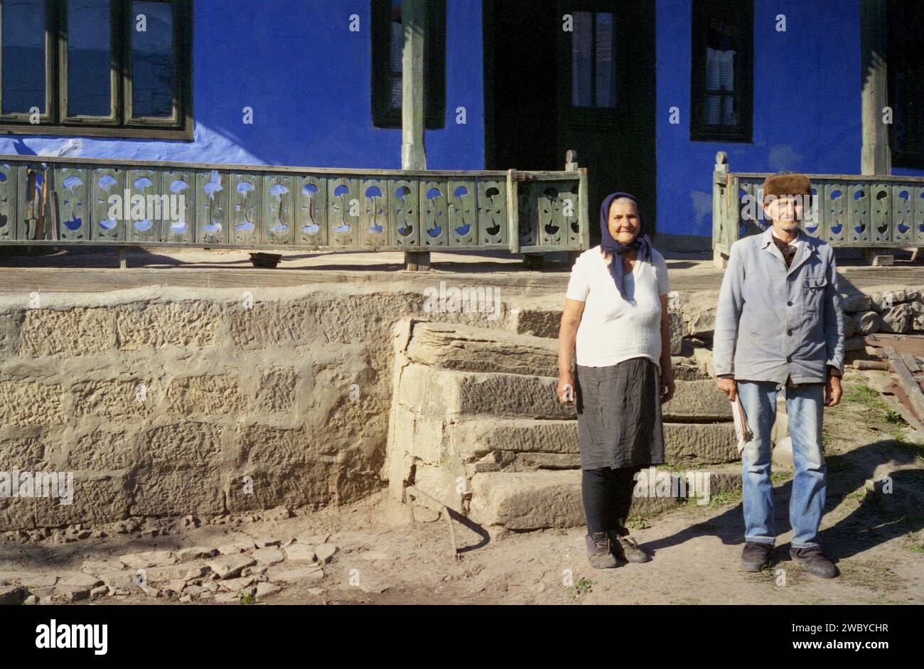 Vrancea County, Romania, approx. 1999. Elderly couple posing in front of their rustic house. Stock Photo