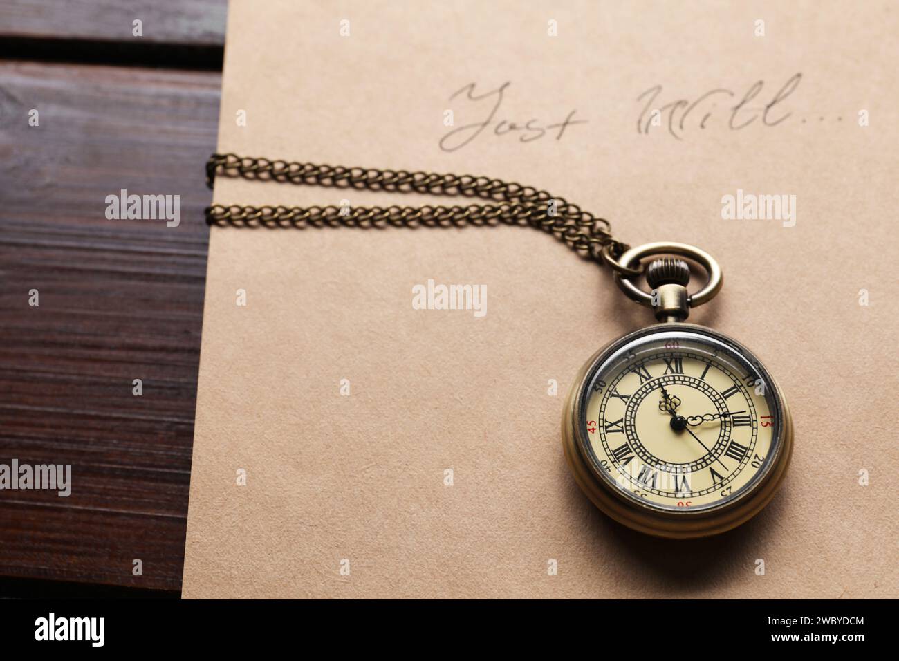 Paper with words Last Will and pocket watch on wooden table, closeup Stock Photo