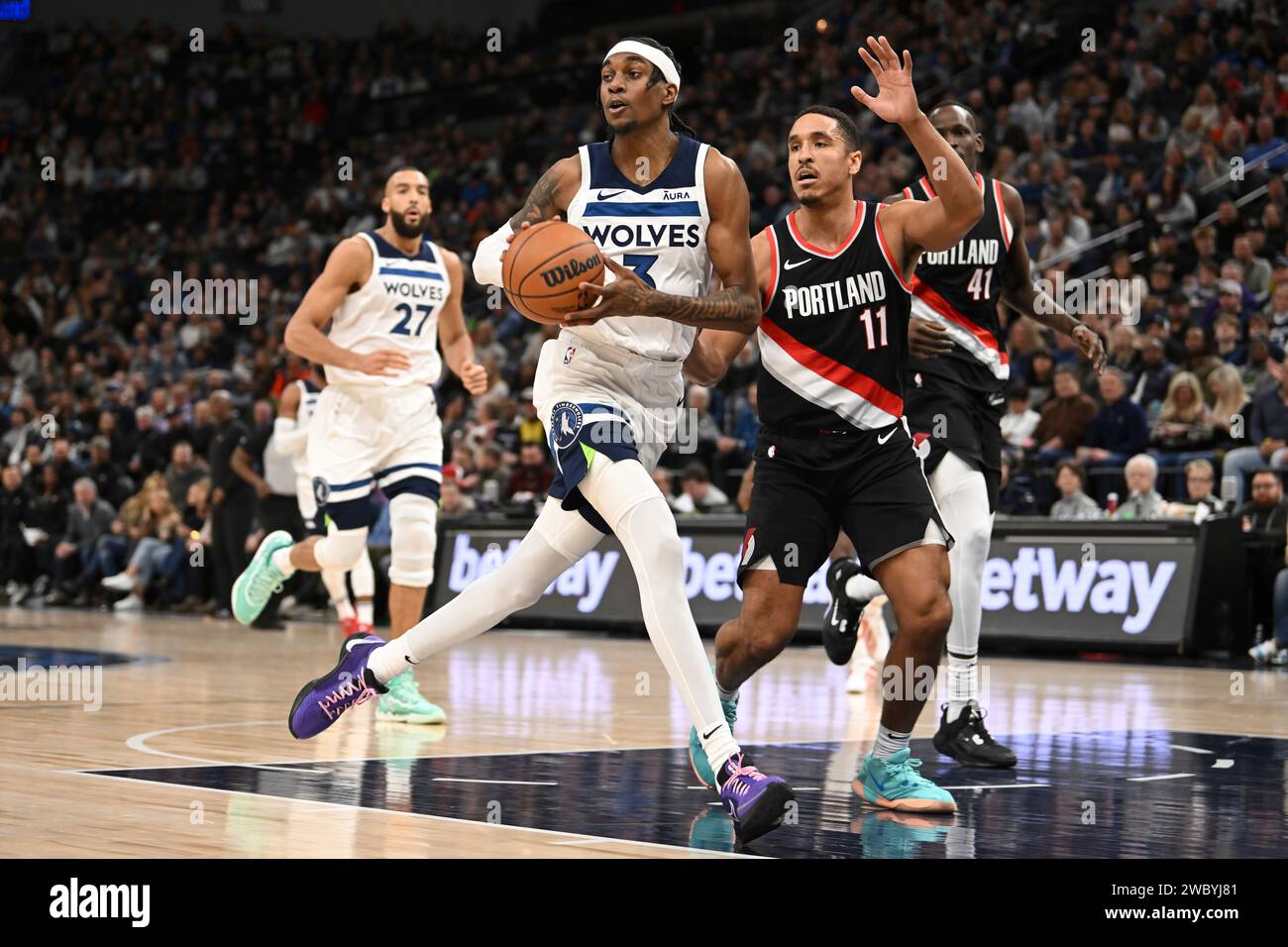 Minnesota Timberwolves forward Jaden McDaniels, left, looks to pass the