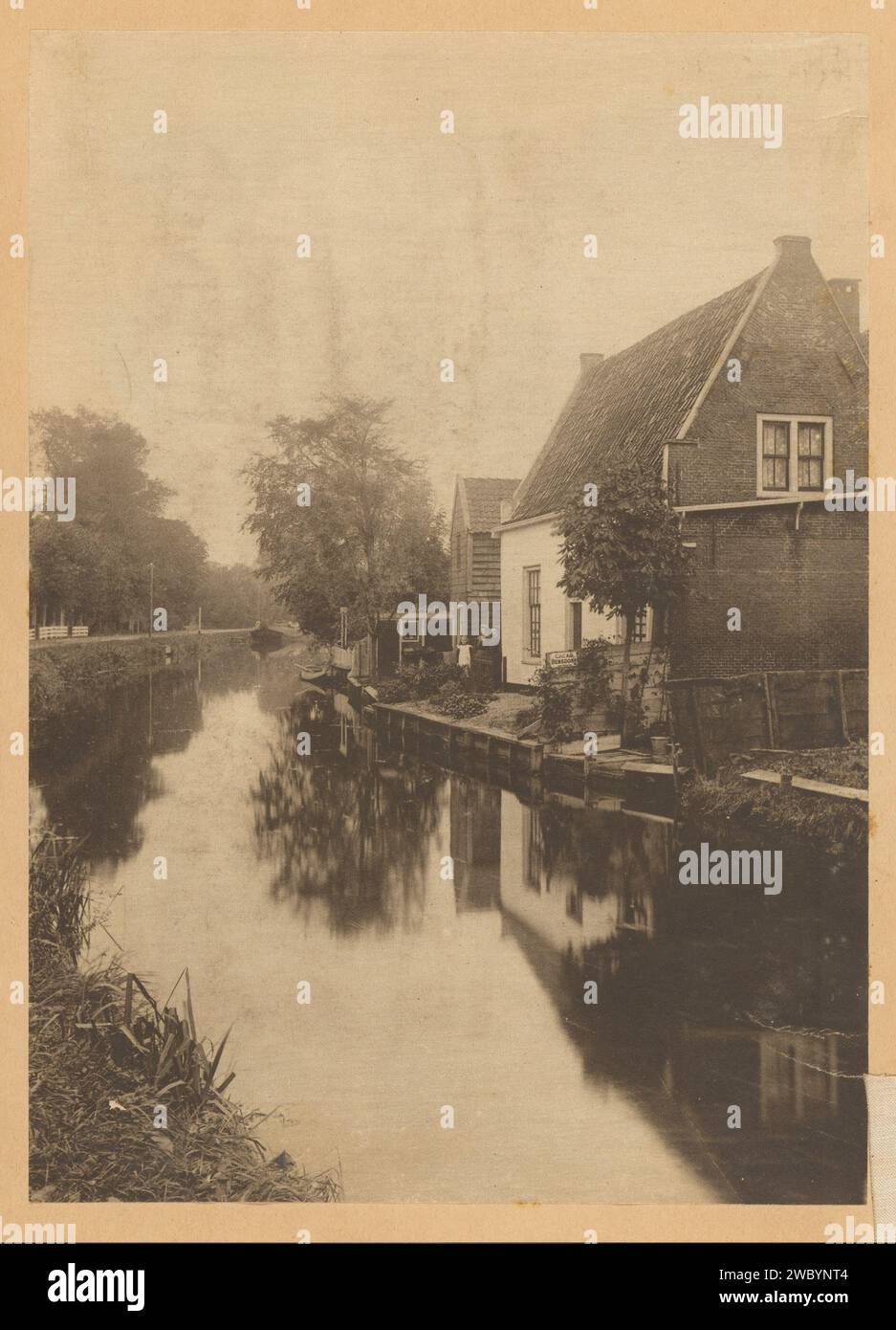 View of Huizen on a speed with the right advertising for Bensdorp-Cacao in the Netherlands, c. 1900 - c. 1920 photograph Part of Family Album with photos of a family in the former Dutch East Indies colony and a sugar factory in Purworejo. Netherlands paper. printing ink  canal. advertising. farm (building) Netherlands Stock Photo