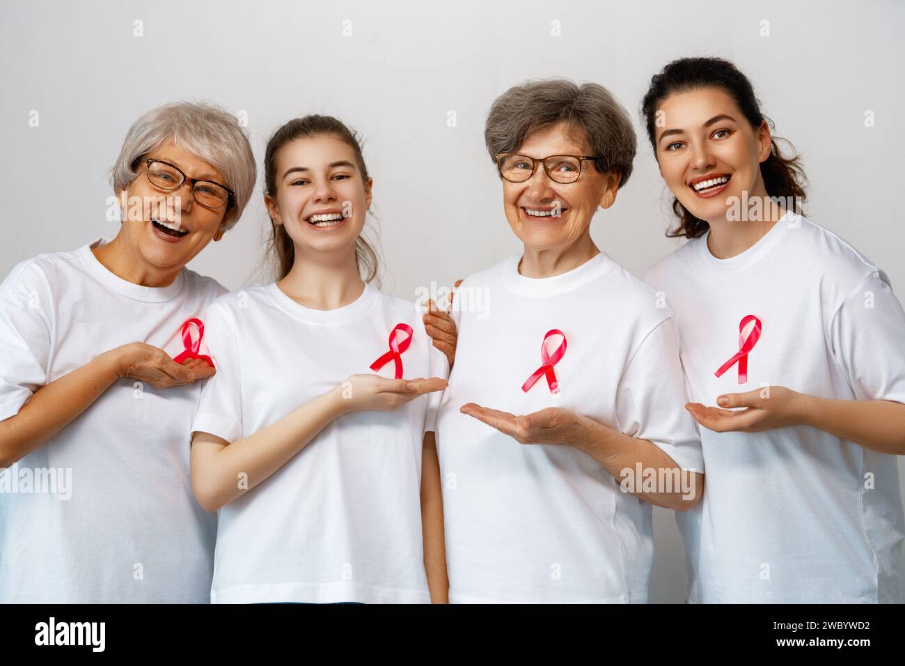 Smiling women with pink satin ribbon symbolizing concept of illness awareness, expressing solidarity and support for cancer patients and survivors. Di Stock Photo