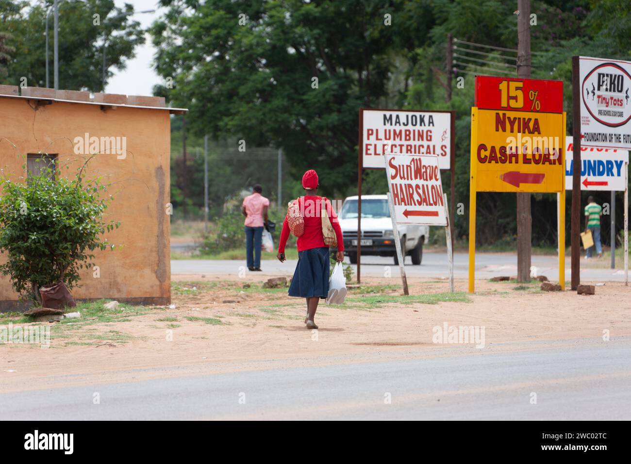 Gaborone, Botswana, 3.19.2010, african woman walking on the street next to some advertising Stock Photo