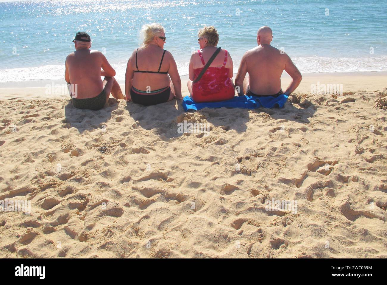 zwei Ehepaare sitzen am Strand von Jandia auf Fuerteventura und sonnen sich gesehen am 08.01 2011 *** two couples sitting on the beach of Jandia on Fuerteventura and sunbathing seen on 08 01 2011 Stock Photo