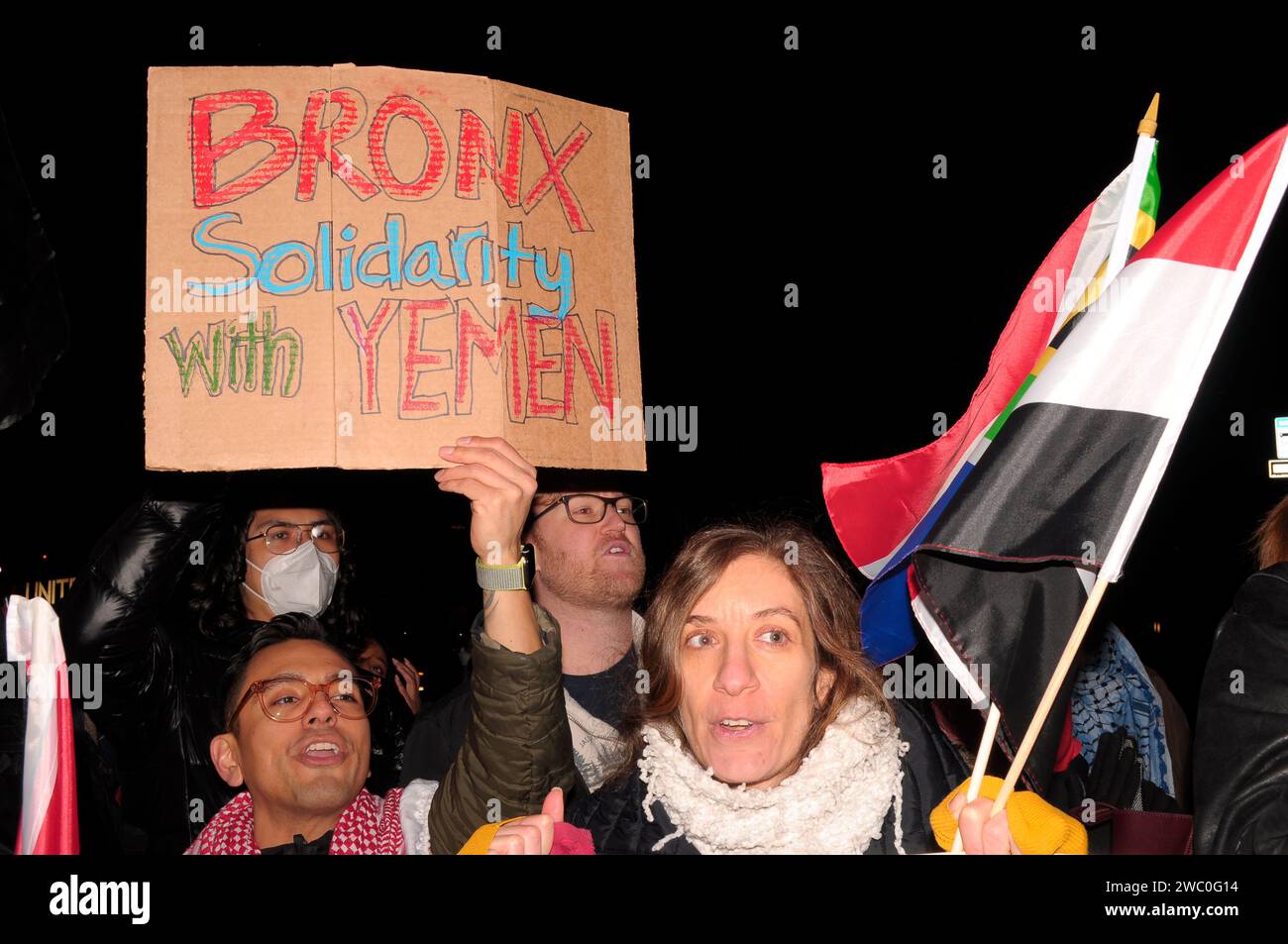 A protester displays a placard that says, 'Bronx Solidarity with Yemen,' while another protestor, right, holds the South African flag and the Yemeni flag at a rally supporting Yemen and Palestine. Hundreds of demonstrators marched in Manhattan, New York City to condemn the U.S. and U.K. militaries who launched airstrikes on Thursday, January 11 against Houthi targets in Yemen. Demonstrators also demanded a permanent ceasefire in the war between Israel and Hamas, and an end to the Israeli military's bombardment of Gaza. According to U.S. President Joe Biden, the January 11 airstrikes in Yemen ' Stock Photo