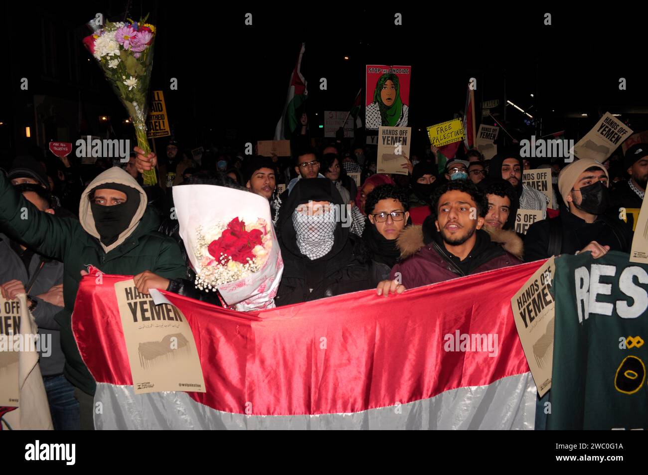 Protestors carry flower bouquets, banners, hold the Yemeni flag and display placards at a rally supporting Yemen and Palestine. Hundreds of demonstrators marched in Manhattan, New York City to condemn the U.S. and U.K. militaries who launched airstrikes on Thursday, January 11 against Houthi targets in Yemen. Demonstrators also demanded a permanent ceasefire in the war between Israel and Hamas, and an end to the Israeli military's bombardment of Gaza. According to U.S. President Joe Biden, the January 11 airstrikes in Yemen 'are in direct response to unprecedented Houthi attacks against intern Stock Photo