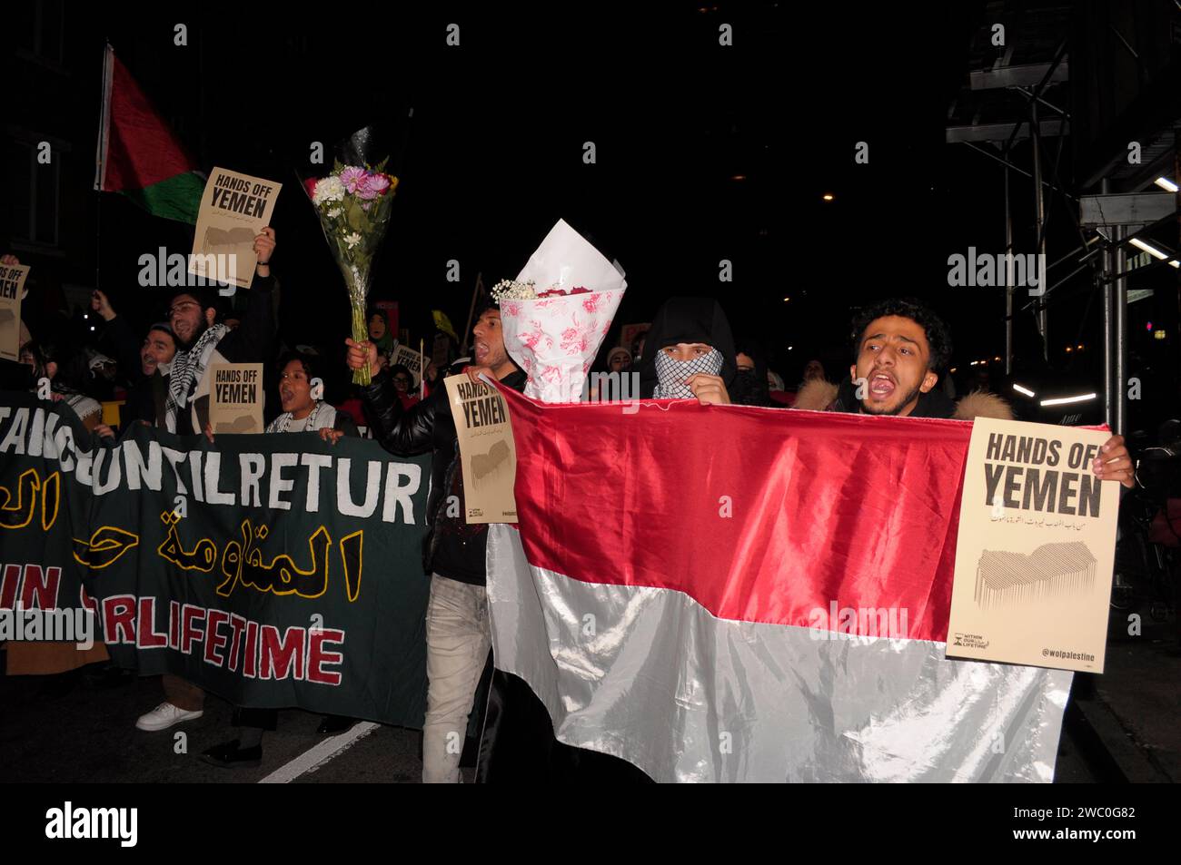 Protestors carry flower bouquets, banners, hold the Yemeni flag and display placards at a rally supporting Yemen and Palestine. Hundreds of demonstrators marched in Manhattan, New York City to condemn the U.S. and U.K. militaries who launched airstrikes on Thursday, January 11 against Houthi targets in Yemen. Demonstrators also demanded a permanent ceasefire in the war between Israel and Hamas, and an end to the Israeli military's bombardment of Gaza. According to U.S. President Joe Biden, the January 11 airstrikes in Yemen 'are in direct response to unprecedented Houthi attacks against intern Stock Photo