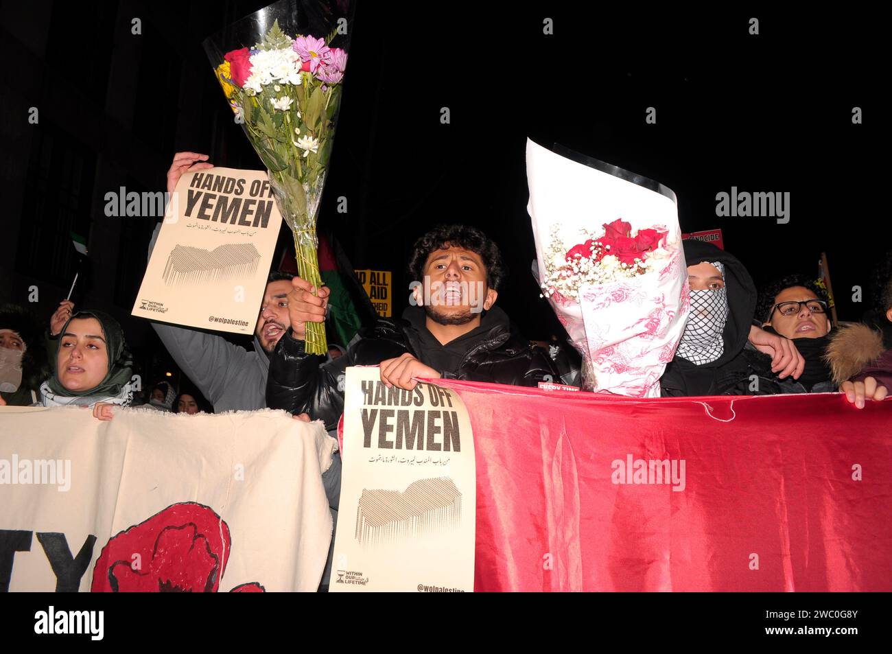 Protestors carry flower bouquets, banners, hold the Yemeni flag and display placards at a rally supporting Yemen and Palestine. Hundreds of demonstrators marched in Manhattan, New York City to condemn the U.S. and U.K. militaries who launched airstrikes on Thursday, January 11 against Houthi targets in Yemen. Demonstrators also demanded a permanent ceasefire in the war between Israel and Hamas, and an end to the Israeli military's bombardment of Gaza. According to U.S. President Joe Biden, the January 11 airstrikes in Yemen 'are in direct response to unprecedented Houthi attacks against intern Stock Photo