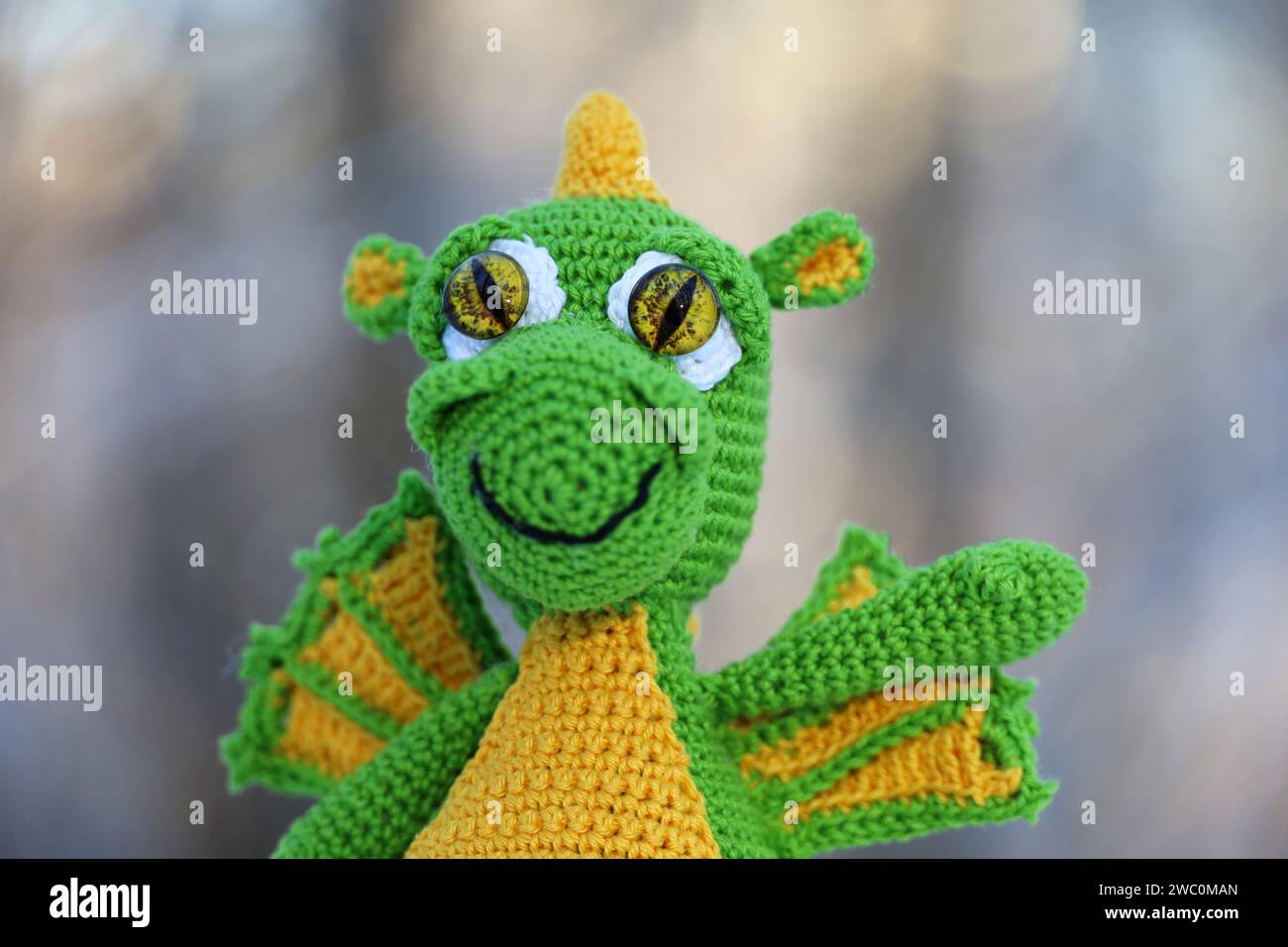 Knitted dragon in a snow on winter forest background, greeting card. Symbol of Chinese New Year 2024 Stock Photo