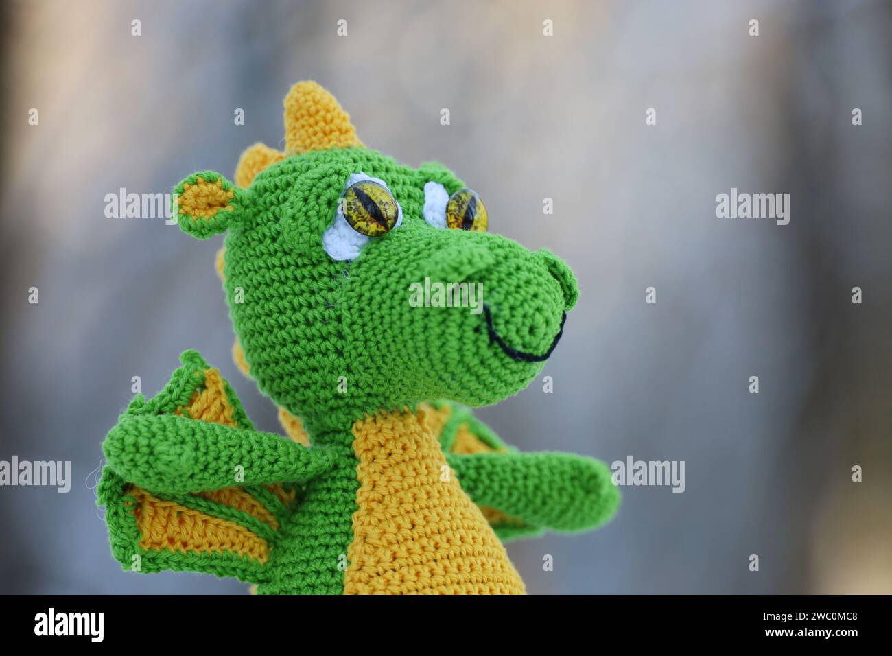 Knitted green dragon on blurred background, greeting card. Symbol of Chinese New Year 2024 Stock Photo