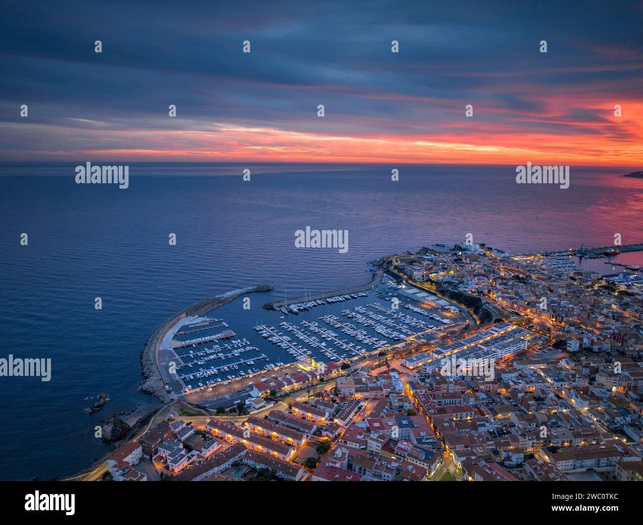 Sunset with a red sky over the bay and city of Palamós. Aerial view (Costa Brava, Baix Empordà, Girona, Catalonia, Spain) Stock Photo