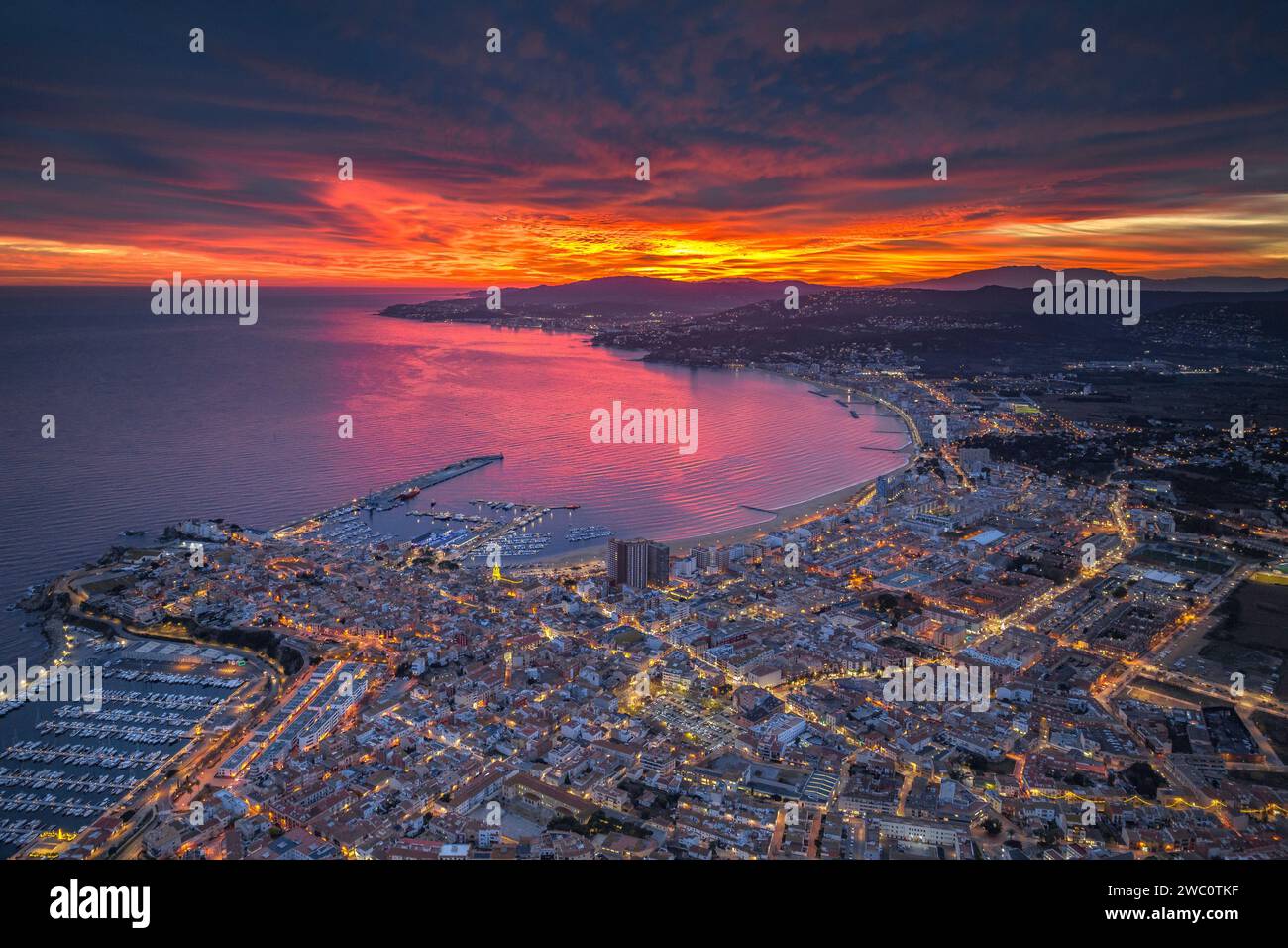 Sunset with a red sky over the bay and city of Palamós. Aerial view (Costa Brava, Baix Empordà, Girona, Catalonia, Spain) Stock Photo