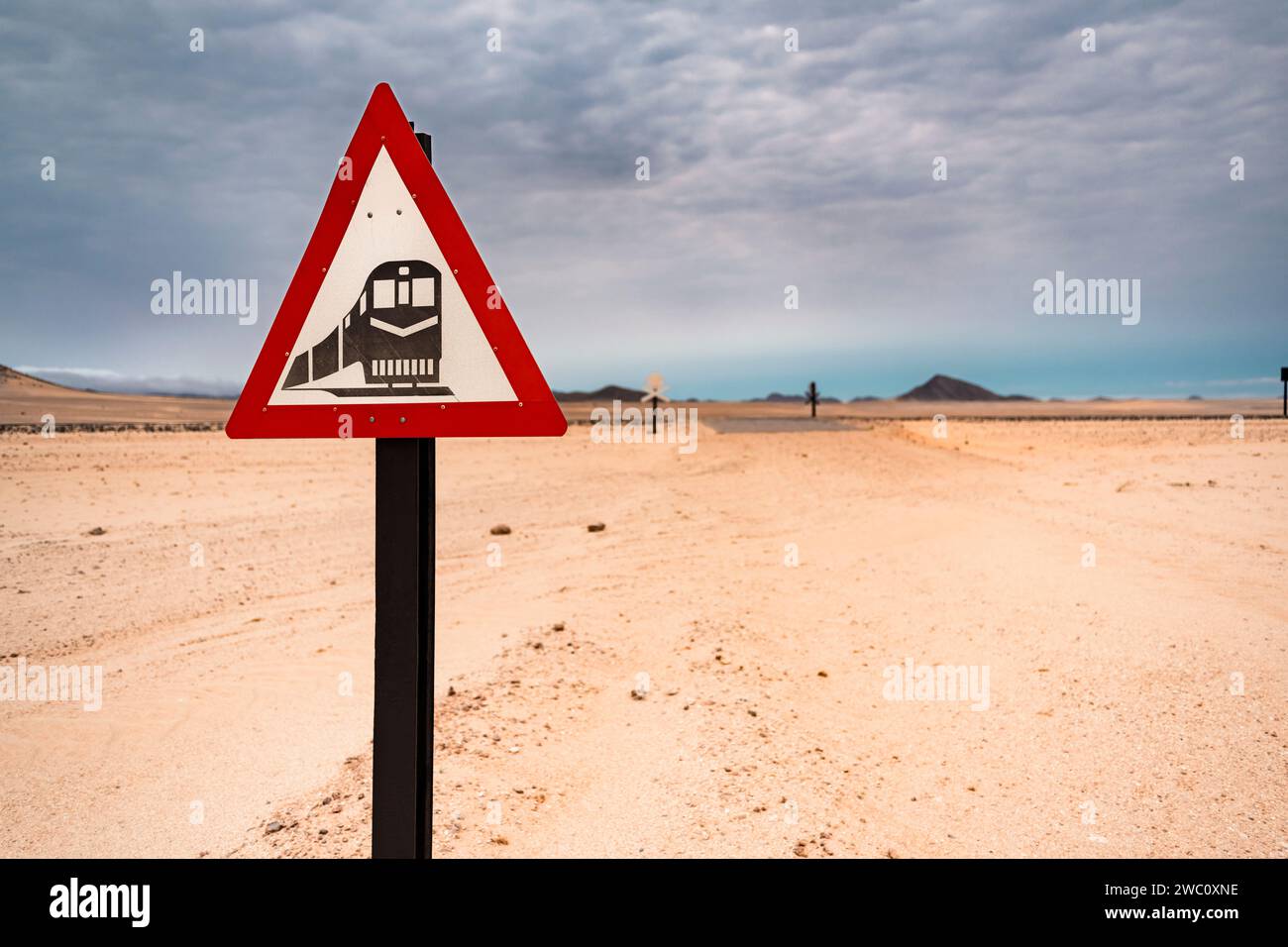 An triangular roadsign warns of railway tracks ahead near Kolmanskop in the desert of Namibia Stock Photo