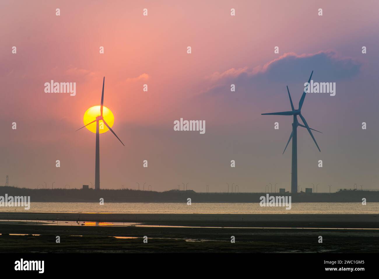 Offshore wind farms are great for enjoying the scenery and watching the sunset. Gaomei Windmill Avenue. Taichung Harbor Wind Power Station. Taiwan. Stock Photo