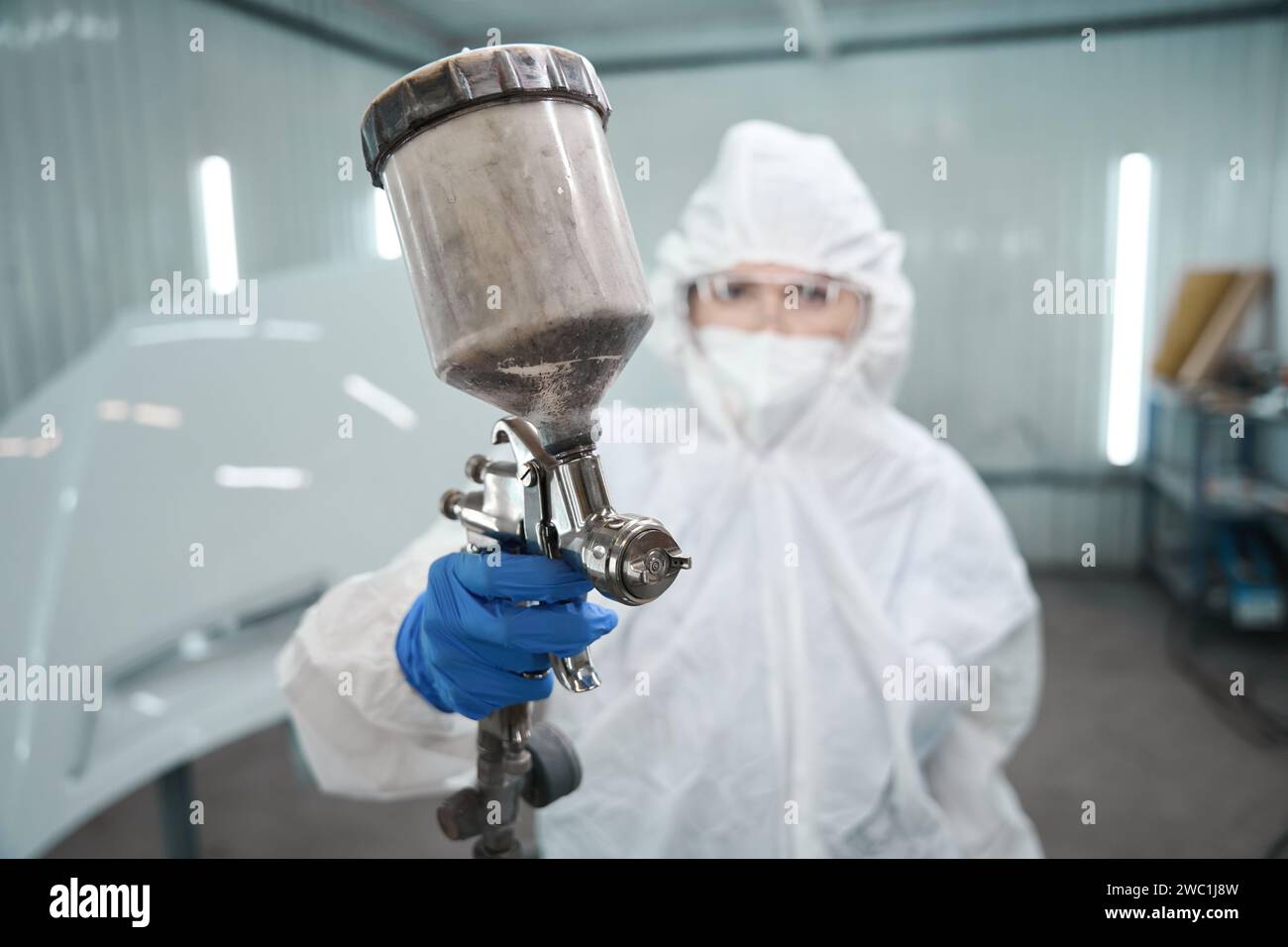 Painting master with a paint injection tank in her hands Stock Photo