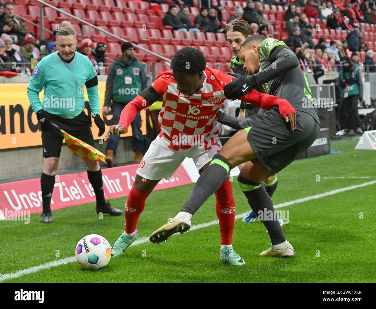 Mainz, Germany. 13th Jan, 2024. Soccer: Bundesliga, FSV Mainz 05 - VfL Wolfsburg, Matchday 17, Mewa Arena: Mainz's Merveille Papela (M) plays against Wolfsburg's Aster Vranckx. Credit: Torsten Silz/dpa - IMPORTANT NOTE: In accordance with the regulations of the DFL German Football League and the DFB German Football Association, it is prohibited to utilize or have utilized photographs taken in the stadium and/or of the match in the form of sequential images and/or video-like photo series./dpa/Alamy Live News Stock Photo