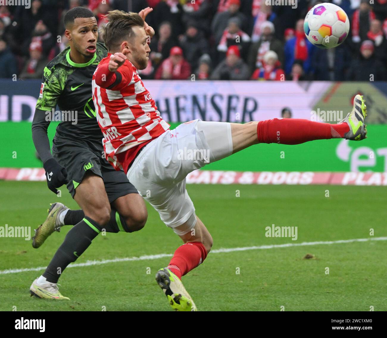 Mainz, Germany. 13th Jan, 2024. Soccer: Bundesliga, FSV Mainz 05 - VfL Wolfsburg, Matchday 17, Mewa Arena: Mainz's Silvan Widmer (r) plays against Wolfsburg's Aster Vranckx. Credit: Torsten Silz/dpa - IMPORTANT NOTE: In accordance with the regulations of the DFL German Football League and the DFB German Football Association, it is prohibited to utilize or have utilized photographs taken in the stadium and/or of the match in the form of sequential images and/or video-like photo series./dpa/Alamy Live News Stock Photo