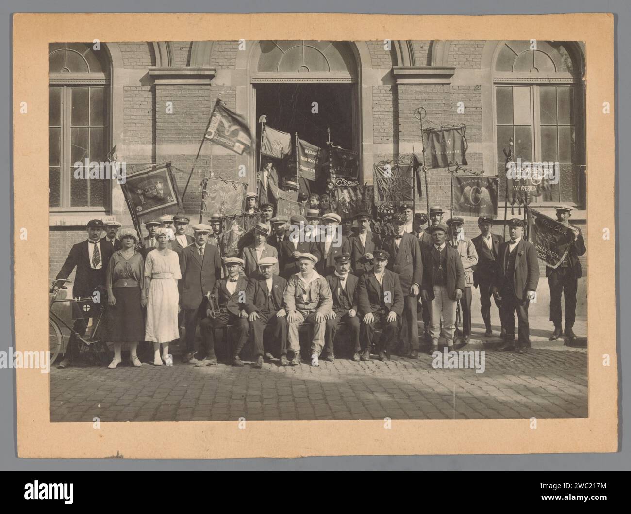 Group portrait of members of the socialist cyclists on a landing, Anonymous, in or after 1921 - c. 1925 photograph  Belgium cardboard. photographic support gelatin silver print anonymous historical persons portrayed in a group, in a group-portrait. façade (of house or building). political parties Stock Photo