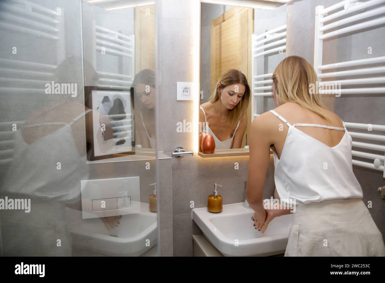 Woman washing hands using soap under water in bathroom sink Stock Photo ...