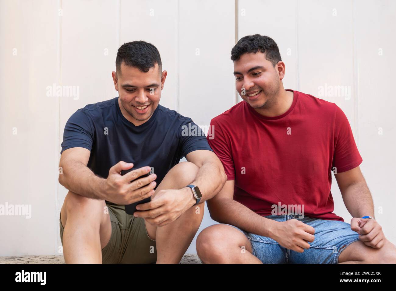 Two men looking smartphone together hi-res stock photography and images ...