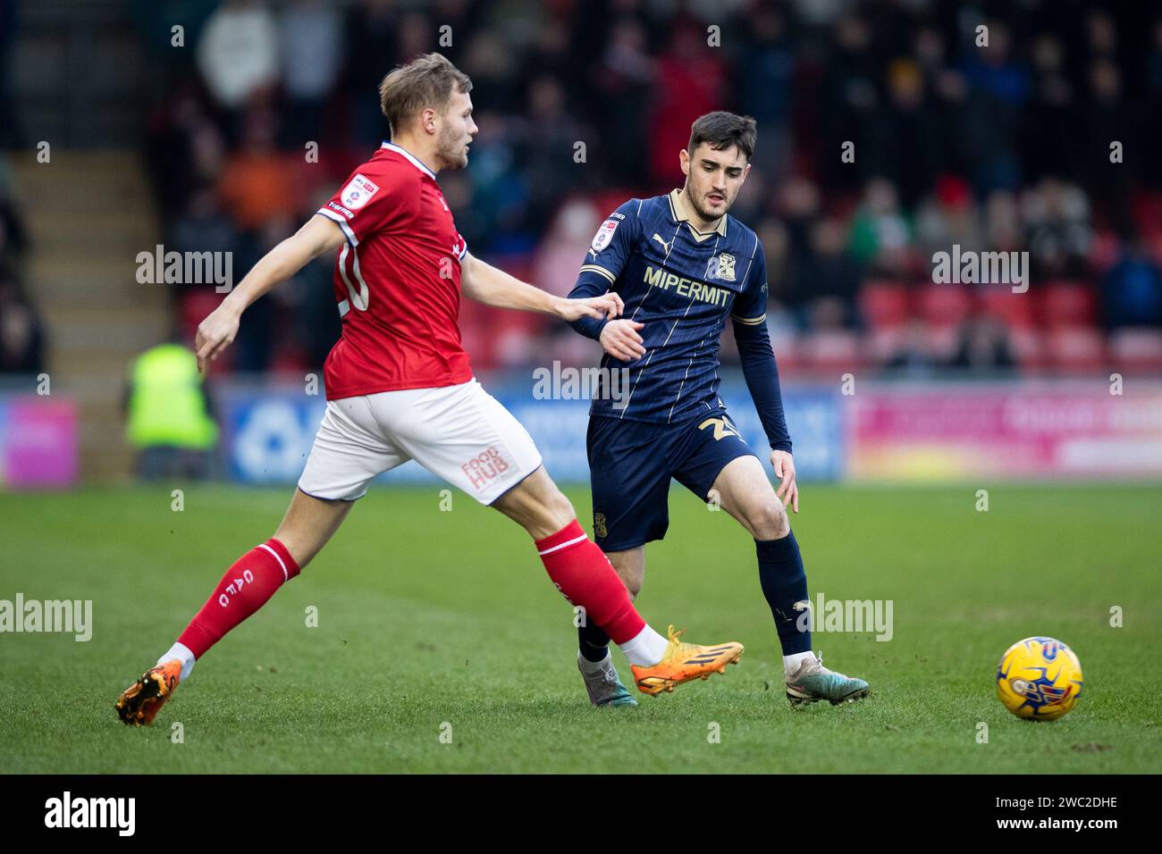 Crewe Alexandra's Elliott Nevitt and Swindon Town's Dawson Devoy battle