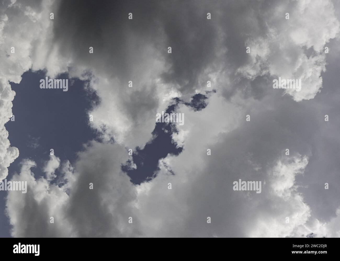 Overcast sky. Solid gray clouds before rain. Low Angle View Of Sunlight Streaming Through Clouds Stock Photo