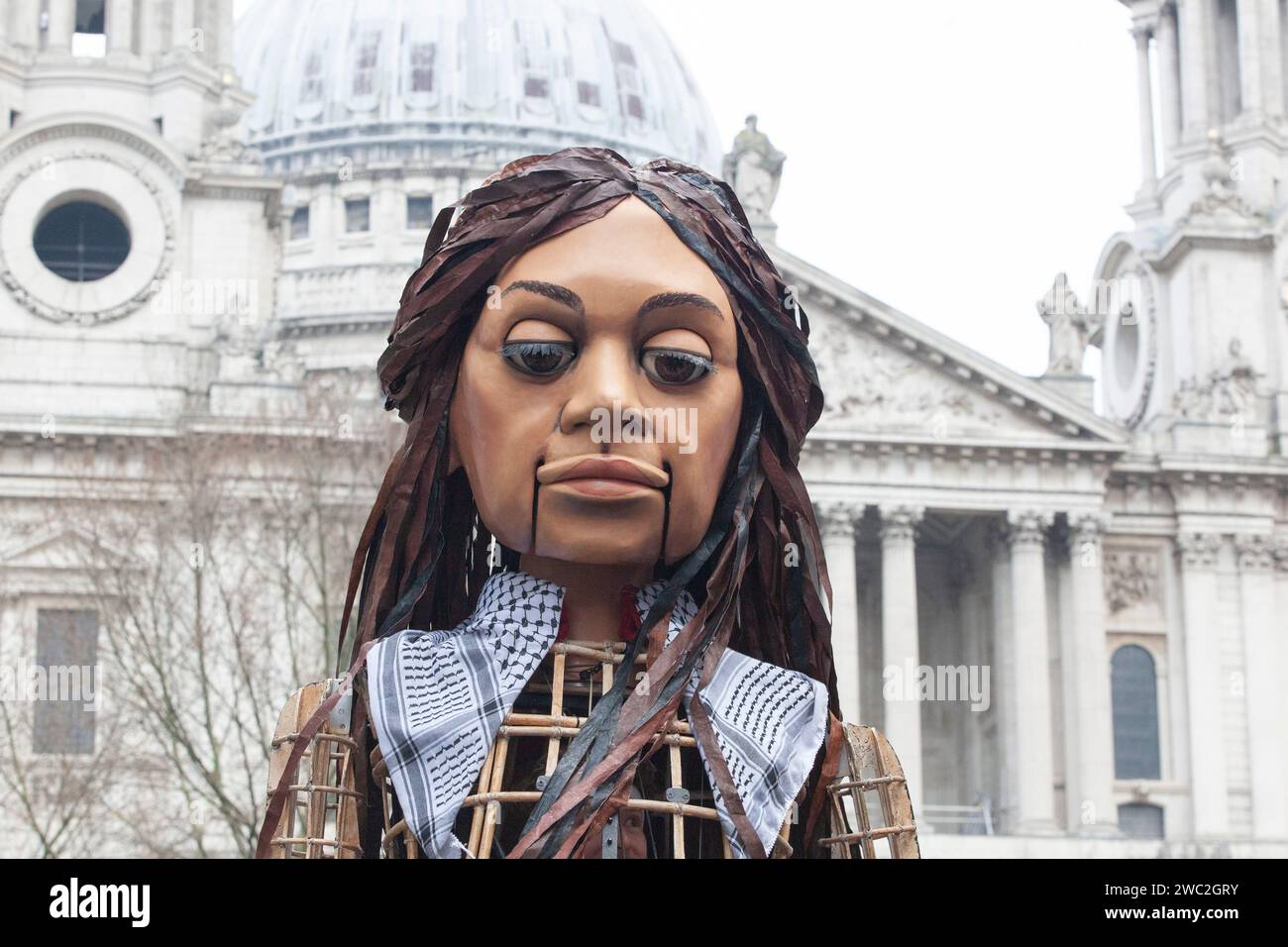 London, UK. 13th Jan, 2024. Thousands of people march past St Paul's Cathedral, calling for a ceasefire in Gaza. Also on ;the march was the giant symbollic puppet Little Amal, representing unaccompanied child refugees. Credit: Anna Watson/Alamy Live News Stock Photo