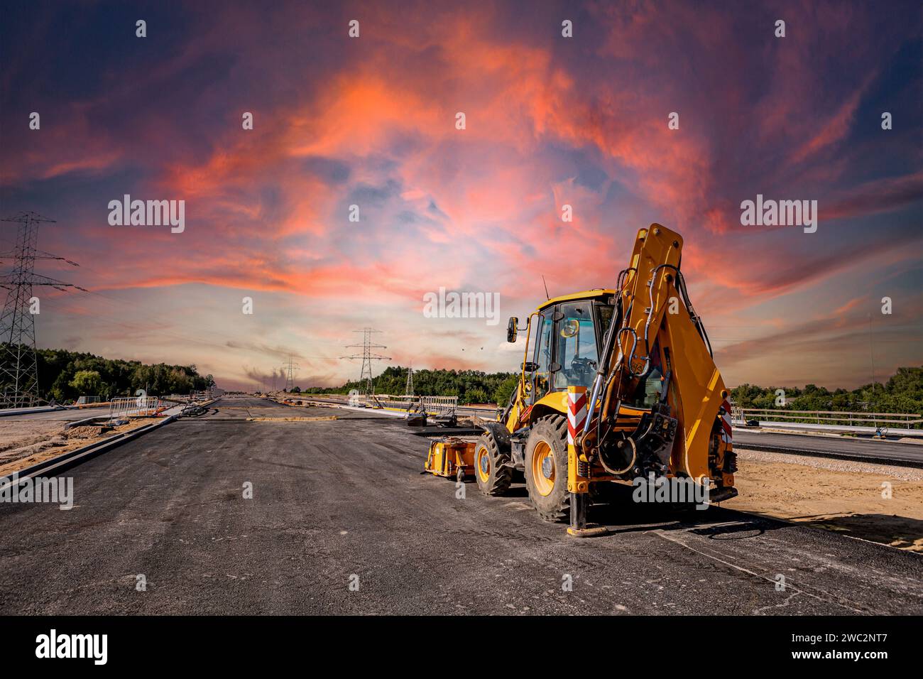 Highway construction. Pouring asphalt, installing sound barriers. Heavy construction equipment on the construction site, roller, excavator, bulldozer Stock Photo